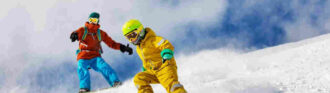 Kind-faehrt-ski-vor-snowboarder