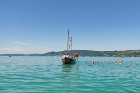 die-kinder-springen-am-ufer-mit-schwimmwesten-ins-wasser