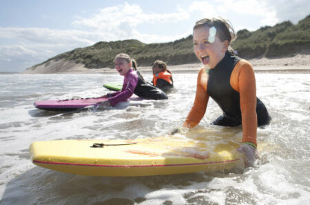 drei-kinder-haben-spass-beim-surfen