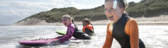 drei-kinder-haben-spass-beim-surfen