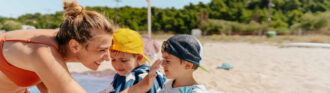 betreuerin-cremt-kids-ein-am-strand