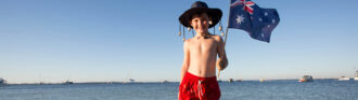 kind-mit-badehose-und-sonnenhut-am-nordseehafen