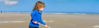 kind-schaufelt-sand-am-strand