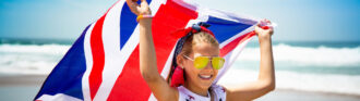 maedchen-steht-mit-grossbritanienflagge-am-strand
