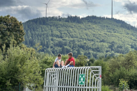 two-boys-are-sitting-on-a-goal-chatting-with-each-other