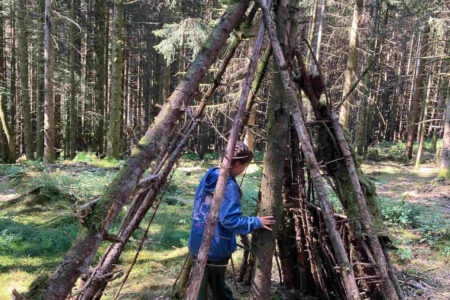 girl-builds-shelter-in-the-forest